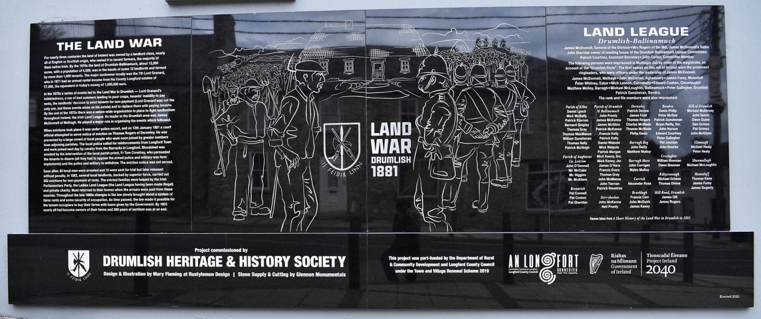 A black plaque with white line art depicts a stand-off between farmers and police during the 1881 Land War in Drumlish. Text panels describe the event, its local impact, and acknowledge project sponsors and the Drumlish Heritage Society.